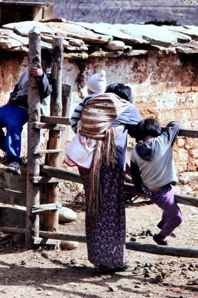 Family resting on a farm fence in Paro. Bhutan.