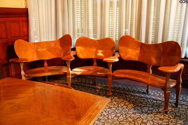 Modernista connected chairs (1904-6) designed for Casa Batlló in Barcelona by Antoni Gaudí at Gaudi House Museum in Parc Güell. Barcelona, Spain.