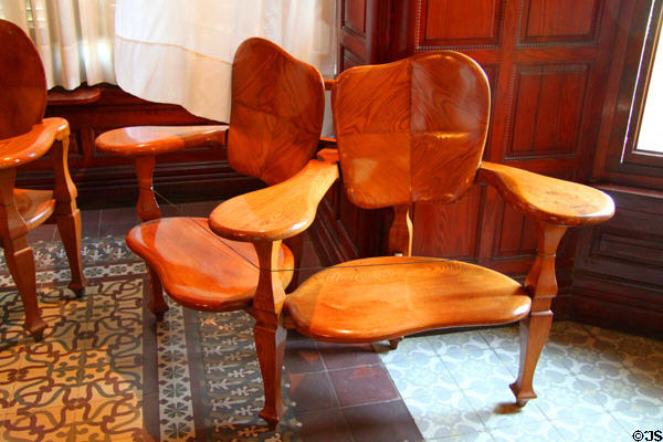 Modernista double chair (1904-6) designed for Casa Batlló in Barcelona by Antoni Gaudí at Gaudi House Museum in Parc Güell. Barcelona, Spain.