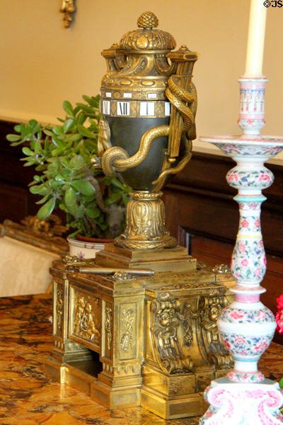 Horizontal cylindrical dial clock in shape of urn wrapped with snakes at Russborough House. Ireland.