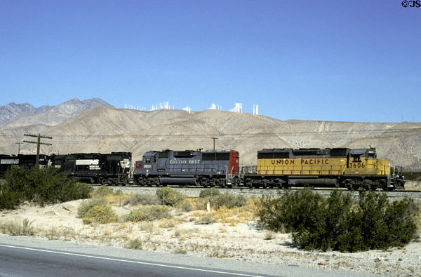 Locomotives pass wind turbines. CA.