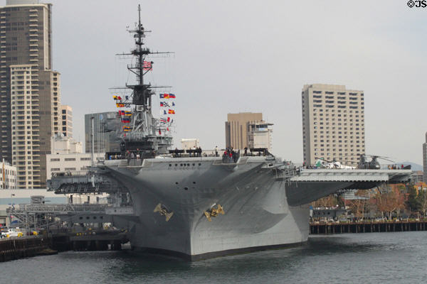 Midway aircraft carrier museum seen from harbor against city skyline. San Diego, CA.