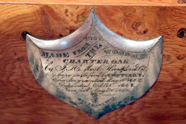 Plaque on piano made from Charter Oak wherein Connecticut's 1662 charter was hidden in 1687 when King James II sent an agent to retrieve & annul the right to its land (the Oak fell in 1856) at Deep River Museum. Deep River, CT.
