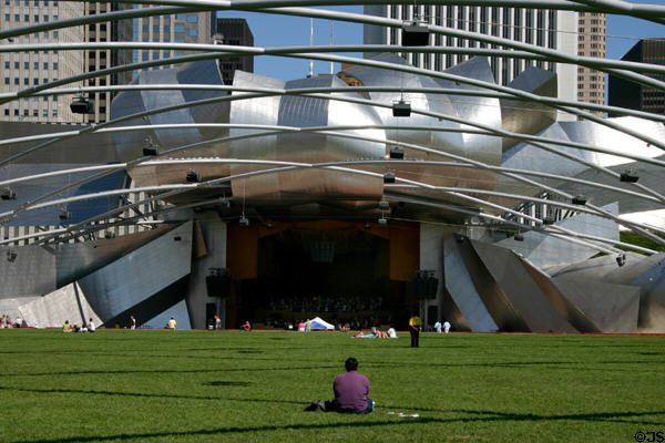Pritzker Pavilion involves audience on Great Lawn by overhead sound system on trellis & by expanding the outdoor concert stage with a freeform metal skin in Millennium Park. Chicago, IL.