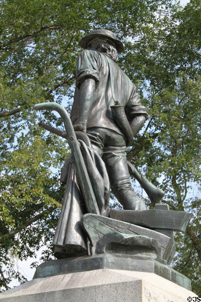 Minute Man statue of colonial farmer with plow, musket & powder horn at Old North Bridge. Concord, MA.