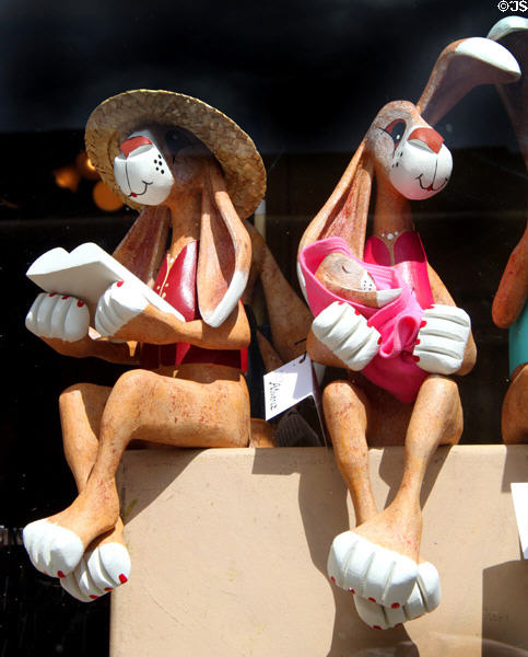 Rabbit carvings with book & baby in Santa Fe shop window. Santa Fe, NM.