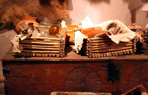 Glass bottles on carved chest at Hacienda de los Martinez. Taos, NM.