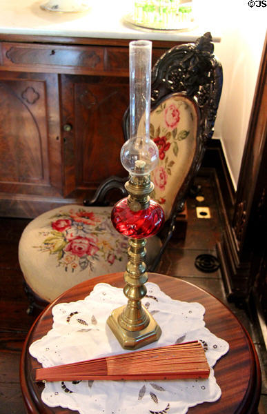 Oil lamp beside side chair at Nichols-Rice-Cherry House at Sam Houston Park. Houston, TX.