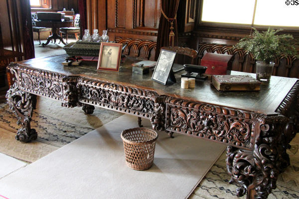 Ornately carved large wooden desk in Library at Penrhyn Castle. Bangor, Wales.