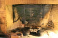 Grange building original cooking fireplace with antique cast iron implements inside Art Gallery of Ontario. Toronto, ON.