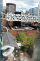 OCAD University's black & white "tabletop" structure standing on poles over Grange heritage original building of Art Gallery of Ontario with its spiral staircase. Toronto, ON