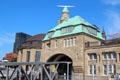Brown dome of Alter Elbtunnel century old tunnel under Elbe & green spires of bridge 6 building of St Pauli Pier. Hamburg, Germany.