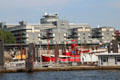 Gray Hamburg New City with round windows over docked red light ship. Hamburg, Germany.