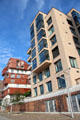 Modern buildings above decorative brickwork flood barrier wall on Dalmannkai in HafenCity. Hamburg, Germany.