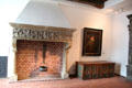 Carved chimney lintel with iron Pothook holding bronze cooking pot beside portrait over medallion chest at Schleswig Holstein State Museum. Schleswig, Germany.