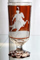 Two-colored stemmed goblet where outer red color is cut away & etched to show military rider from Bohemia at Coburg Castle. Coburg, Germany.