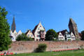 Ulm brick city wall overlooked by Ulm Münster, step gabled building with half-timbered oriel windows & ancient city gate of Metzgerturm. Ulm, Germany