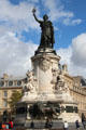 Bronze Marianne symbol of France atop carved monument representing liberty, equality, & fraternity over lion guarding ballot box by Charles & Léopold Morice at Place de la République. Paris, France.