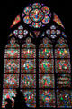 Virgin circled by musical angels over Medieval worship scenes stained glass window in Notre Dame Cathedral. Paris, France.