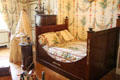 Empire-style bed in nursery with cradle beyond at Cheverny Chateau. Cheverny, France.
