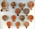 Roman-era ceramic oil lamps with molded decorative scenes mostly found in Rhone River at Arles Antiquities Museum. Arles, France.