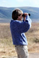 Tourist scans Ngorongoro Park. Tanzania.