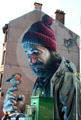 Mural of Saint with birds on end of Bell o'the Brae Tenements. Glasgow, Scotland