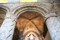 Arch with ancient paintings of saints between carved columns in nave of Dunfermline Abbey. Dunfermline, Scotland.