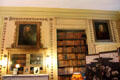 Book shelves and ornately framed portraits in Chinese sitting room at Newhailes. Musselburgh, Scotland.