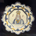 Ceramic plate , with scalloped edges & portrait & initials of James II, made in Brislington near Bristol at Bristol Museum & Art Gallery. Bristol, England.