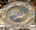 Tin-glazed earthenware oval dish with molded reliefs & painted with baroque scene from Southwark, London at British Museum. London, United Kingdom.