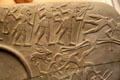 Details of Egyptian predynastic mudstone carved palette for grinding eye paint with hunters' scene at British Museum. London, United Kingdom.