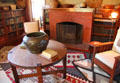 Round arts & crafts table with copper vase before library fireplace at Marston House Museum. San Diego, CA.