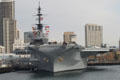 Midway aircraft carrier museum seen from harbor against city skyline. San Diego, CA.