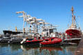 Official boats at Jack London Square docks with cranes beyond. Oakland, CA.
