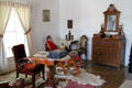 Bedroom with table & dresser at Baca Adobe House. Trinidad, CO.