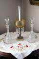 Cut glass decanters & candle luster on embroidered cloth at Isham-Terry House Museum. Hartford, CT.