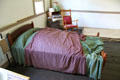 Queen Lili'uokalani's bedroom with her purple dress in Oldest Frame House of Mission House Museum. Honolulu, HI.