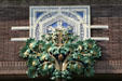 Terra cotta tree of leaves & geometric shield on Van Allen Dry Goods Store. Clinton, IA.