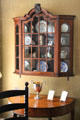 Display cabinet with china over side table at Nichols House Museum. Boston, MA.