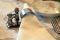 Ornate napkin holder with place setting in dining room at Ida Saxton McKinley Historic House. Canton, OH.