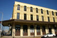 Brown Victorian building with covered sidewalk. Galveston, TX.