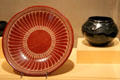 Red plate with feather decoration by Maria Martinez & Popovi Da plus carved black jar by Antonio & Juanita Peña all of San Ildefonso at McNay Art Museum. San Antonio, TX.