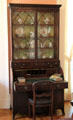 Rolltop desk with bookcase displaying porcelain in parlor at Neill-Cochran House Museum. Austin, TX.