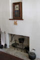 Shelf clock with crossed US flag design above fireplace in Baetge House at Conservation Plaza. New Braunfels, TX.