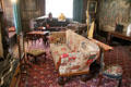 Music room with patchwork covered sofa & fire screen with wood spooled frame at St Fagans Castle. Cardiff, Wales.