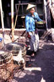 Woman carrying fruit through bird market. Jogyakarta, Indonesia.