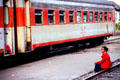 Woman sits on track at rail station. Jogyakarta, Indonesia.