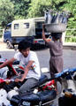 Woman carries fish on head on street in Denpasar. Bali, Indonesia.