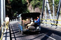 Jitney carrying crops across bridge. Bali, Indonesia.